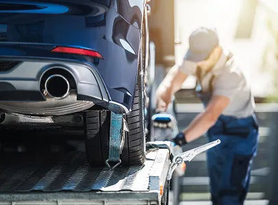 Un homme attache une voiture bleue sur une dépanneuse à Saint-Orens près de Toulouse en Haute-Garonne 31
