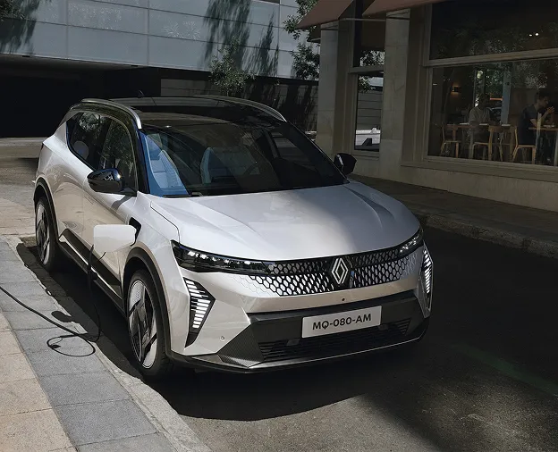 SUV électrique Renault blanc argenté garé et en charge sur un trottoir urbain à Saint-Orens près de Toulouse en Haute-Garonne 31